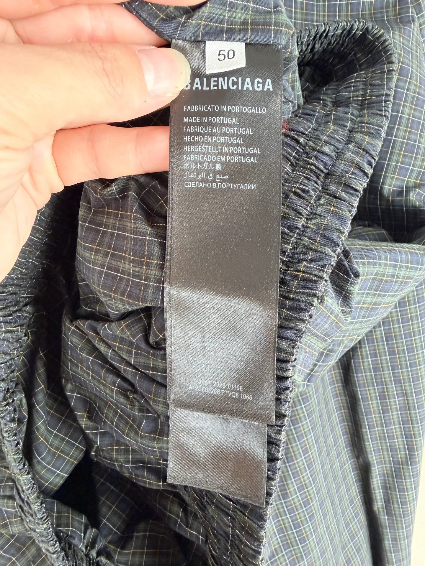 BALENCIAGA/balenciaga SS 26 two-way zipper opening and closing embroidered plaid jacket is based on the full-area no-dead-corner grid technology as the technical core, superimposed on multiple difficult processes such as two-way zipper composite structure, positioning heavy embroidery, and full-cut symmetrical sewing. The complexity of the process and the scrap rate are far higher than that of conventional garments. It is a ceiling-level presentation of street luxury craftsmanship. This product is made of custom-made yarn-dyed plaid original fabric. It needs to complete four pre-processing processes of ultra-dense pre-shrinking, weft density correction, tension leveling and flat-width shaping before being put into production. The shrinkage error of the fabric's longitude and latitude is strictly controlled within 0.2%, which completely eliminates the hidden dangers of plaid deformation and alignment deviation after the garment is worn, laying an irreplaceable foundation for the whole piece to align. The pre-processing time of a single fabric is three times that of an ordinary jacket. The core process difficulty is the full-area through-alignment technology, which requires all exposed pieces such as the front and rear panels of the body, large and small sleeve panels, lapel collars, pocket flap welts, placket stops, and side seam panels to achieve horizontal penetration of horizontal grids, vertical alignment of vertical grids, and complete mirror symmetry of left and right panels. The alignment tolerance is strictly controlled within 0.1mm, and the industry standard is only 0.5mm. Cutting pieces are arranged using a zero-loss precise positioning method. The loss rate of a single fabric is increased by 20%. Any deviation in the pattern of the cutting pieces is judged as a defective product. The experience and precision requirements of the cutting masters have reached a strict level. At the structural level, it is equipped with a two-way double-head customized zipper opening and closing system. The zipper tooth chain and placket pattern must be 100% aligned in the center seam. When the zipper is installed, the plaid alignment and stop smoothness are simultaneously completed to prevent the plaid from being pulled or skewed due to zipper installation. The front loop sportsicon heavy embroidery adopts positioning embedded technology. The embroidery stitches need to accurately follow the warp and weft direction of the check pattern. The positioning error of the embroidery frame does not exceed 0.05mm. The floating embroidery process avoids the stitch tension from pulling the fabric texture and achieves the perfect symbiosis between the embroidery pattern and the check texture. The entire garment adopts segmented alignment sewing and full-process quality inspection and control. From cut pieces to finished products, it needs to undergo 7 alignment checks. Every seam, structural line, and decorative piece serves the integrity of the pattern. The complexity of the process, labor cost, and quality control standards are all benchmarked against the high-end garment level. It has both pioneering design and unrepeatable ingenious workmanship. Size: 46 48 50 52
